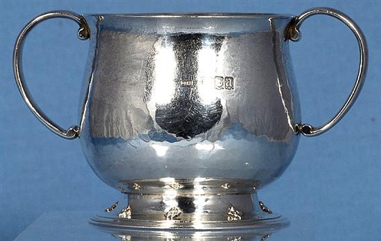 A George V Arts & Crafts silver two handled cup, Width to handles 5”/128mm Height 3”/78mm Weight 7oz/197grms